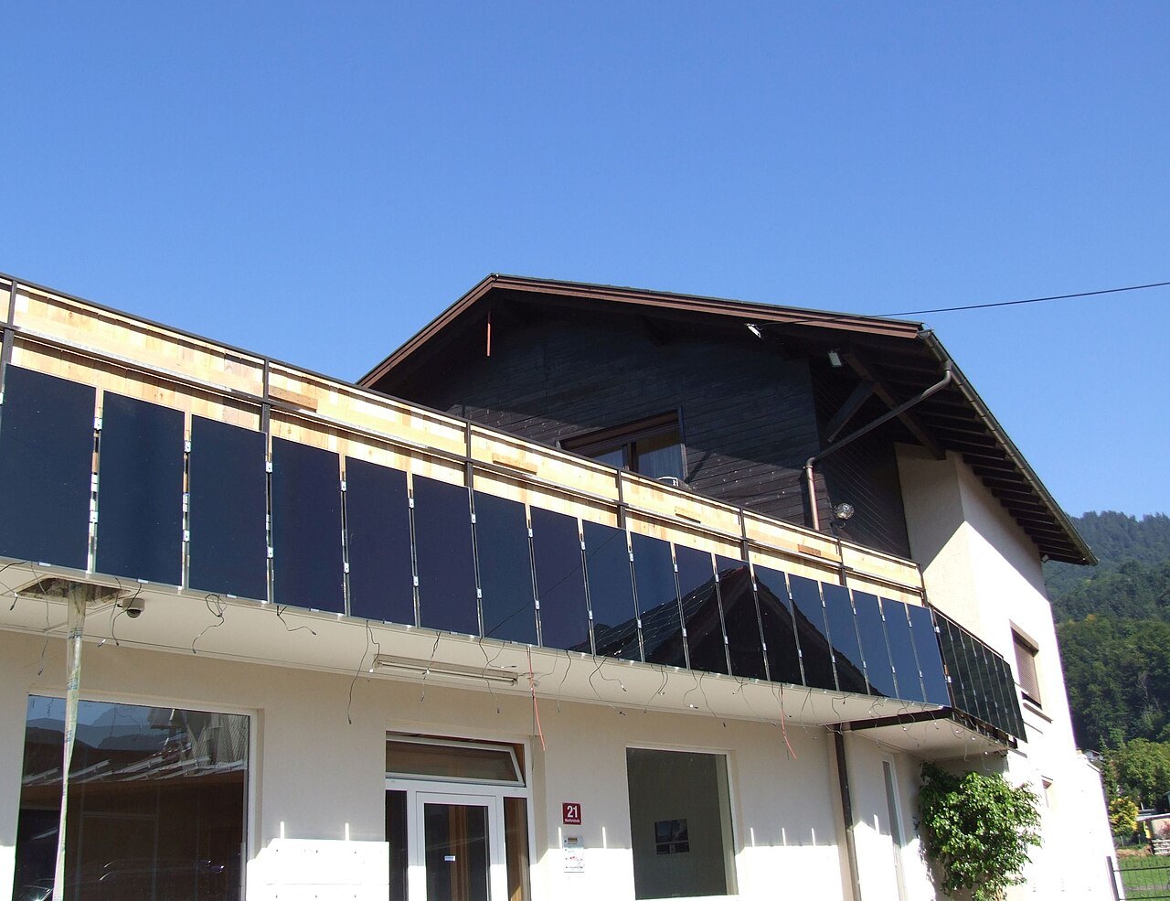 Due pannelli fotovoltaici fissati alla ringhiera di un balcone di un condominio, inclinati verso il sole