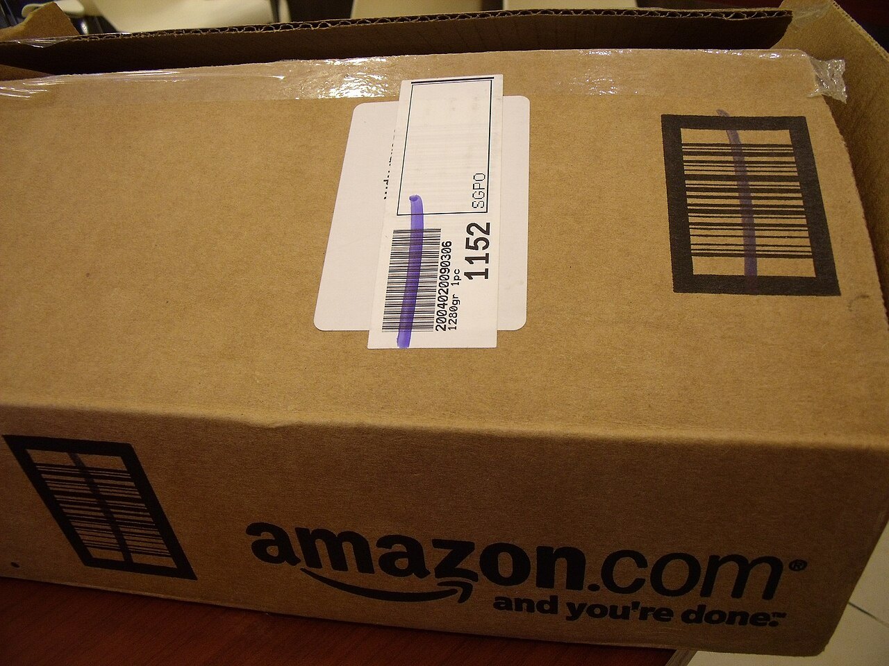 Pacco Amazon in cartone con etichetta di spedizione e codici a barre