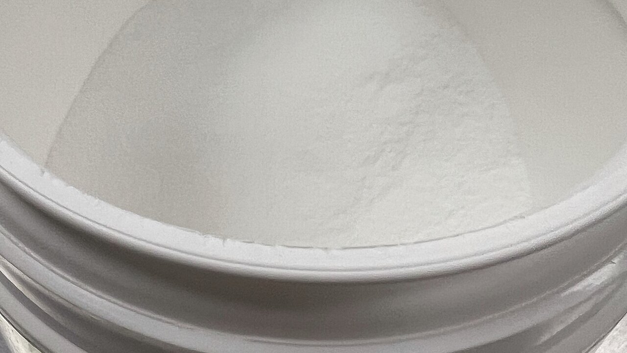 Barattolo aperto di creatina monoidrato in polvere bianca