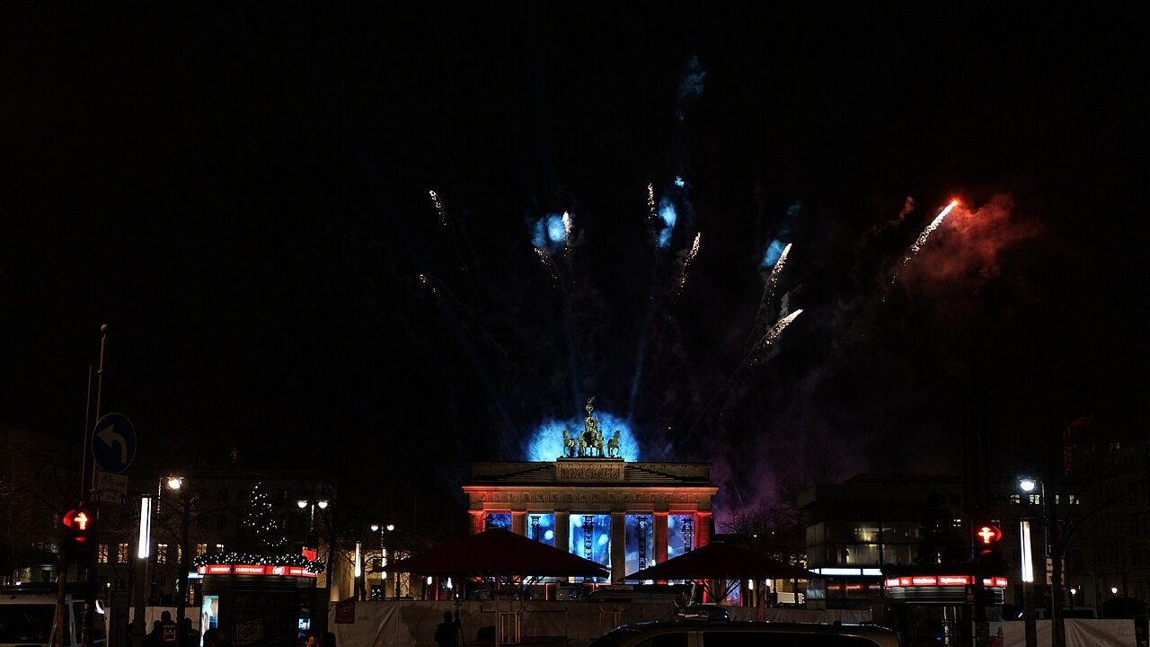Fuochi d'artificio di Capodanno sopra la Porta di Brandeburgo a Berlino, vista da Unter den Linden