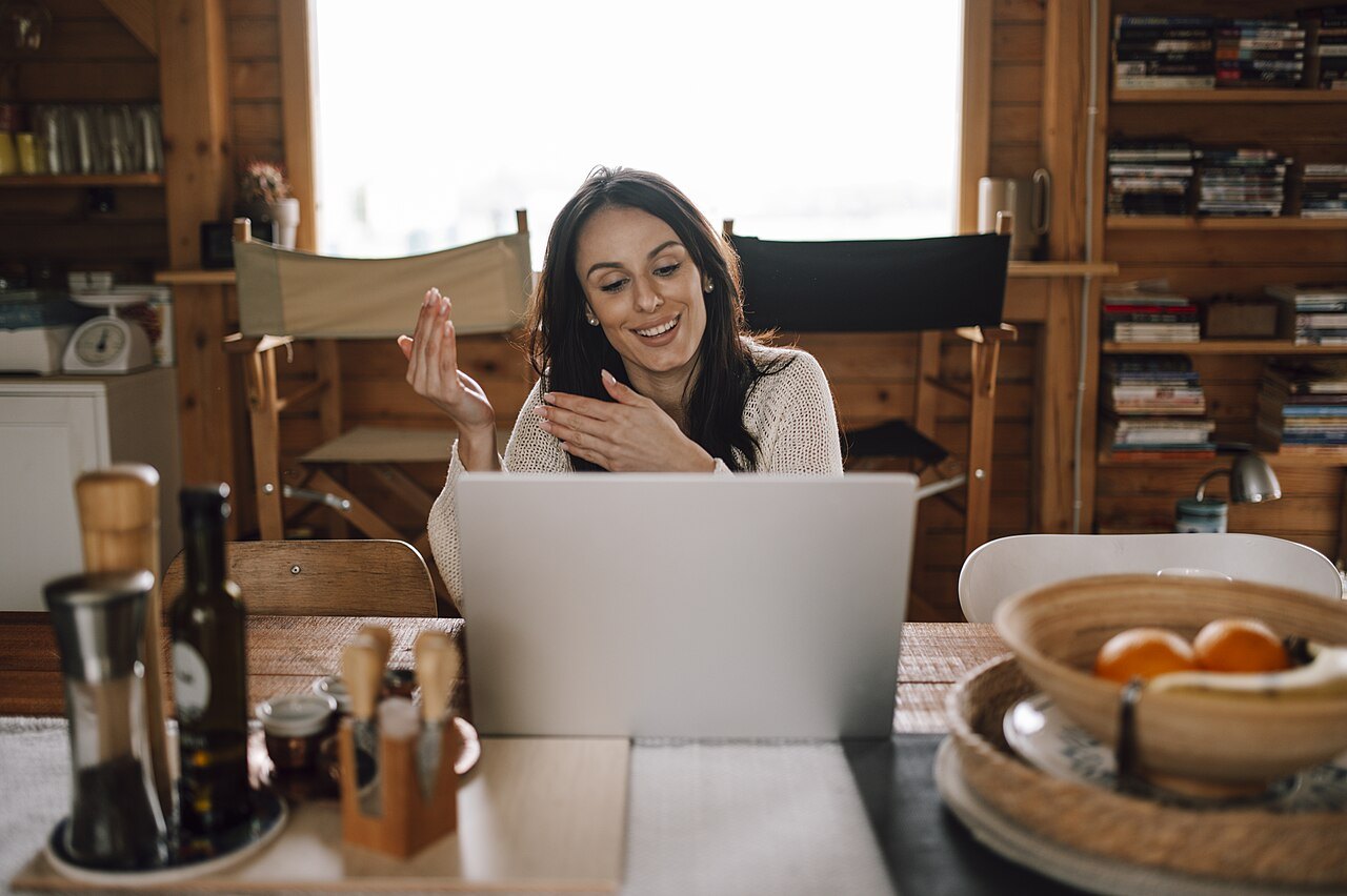 Donna sorridente che parla in videochat dal portatile